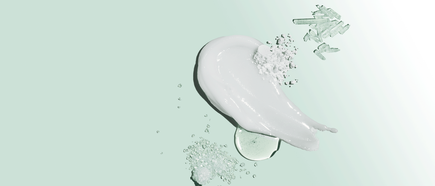 Toothpaste cream close-up with powder and crystals on light green background