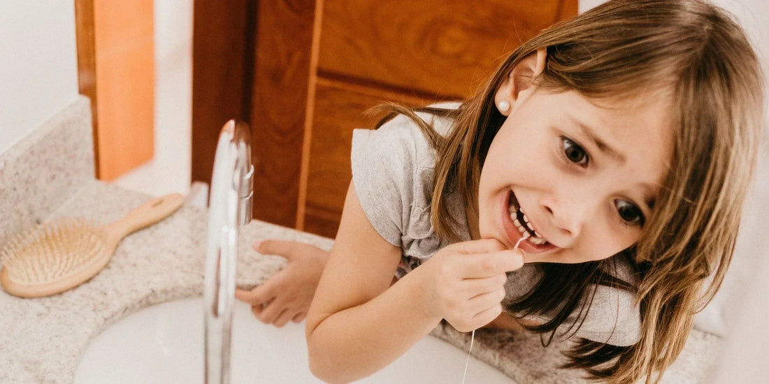 A young girl flosses