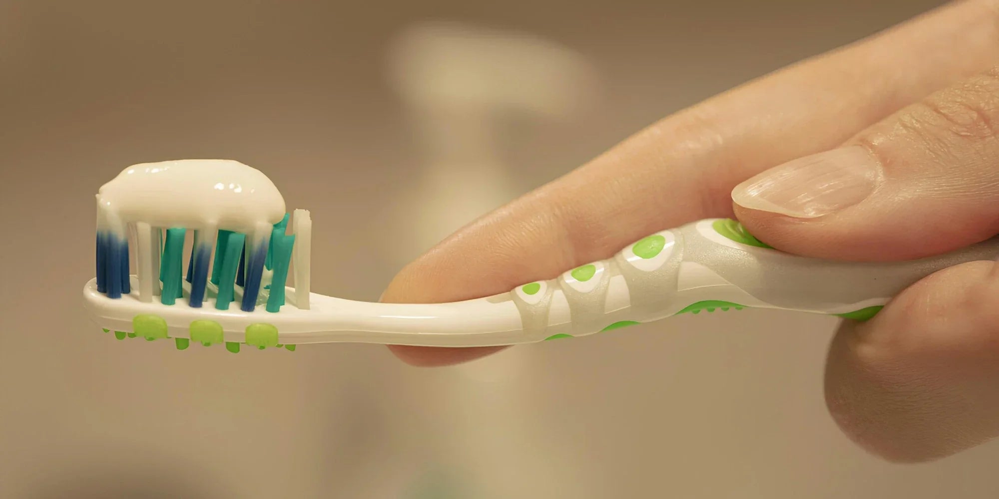 A white mild abrasive toothpaste applied to a manual toothbrush.
