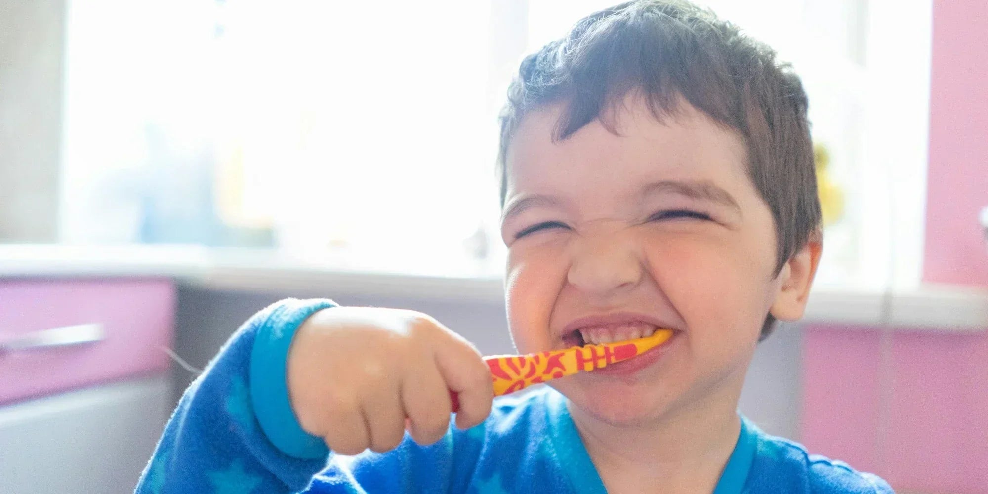 close-up of a smiling boy brushing his teeth