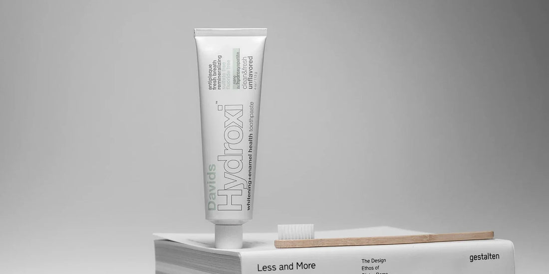 Davids unflavored toothpaste next to a bamboo toothbrush