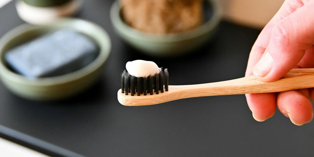 A dollop of xylitol toothpaste on a bamboo toothbrush.