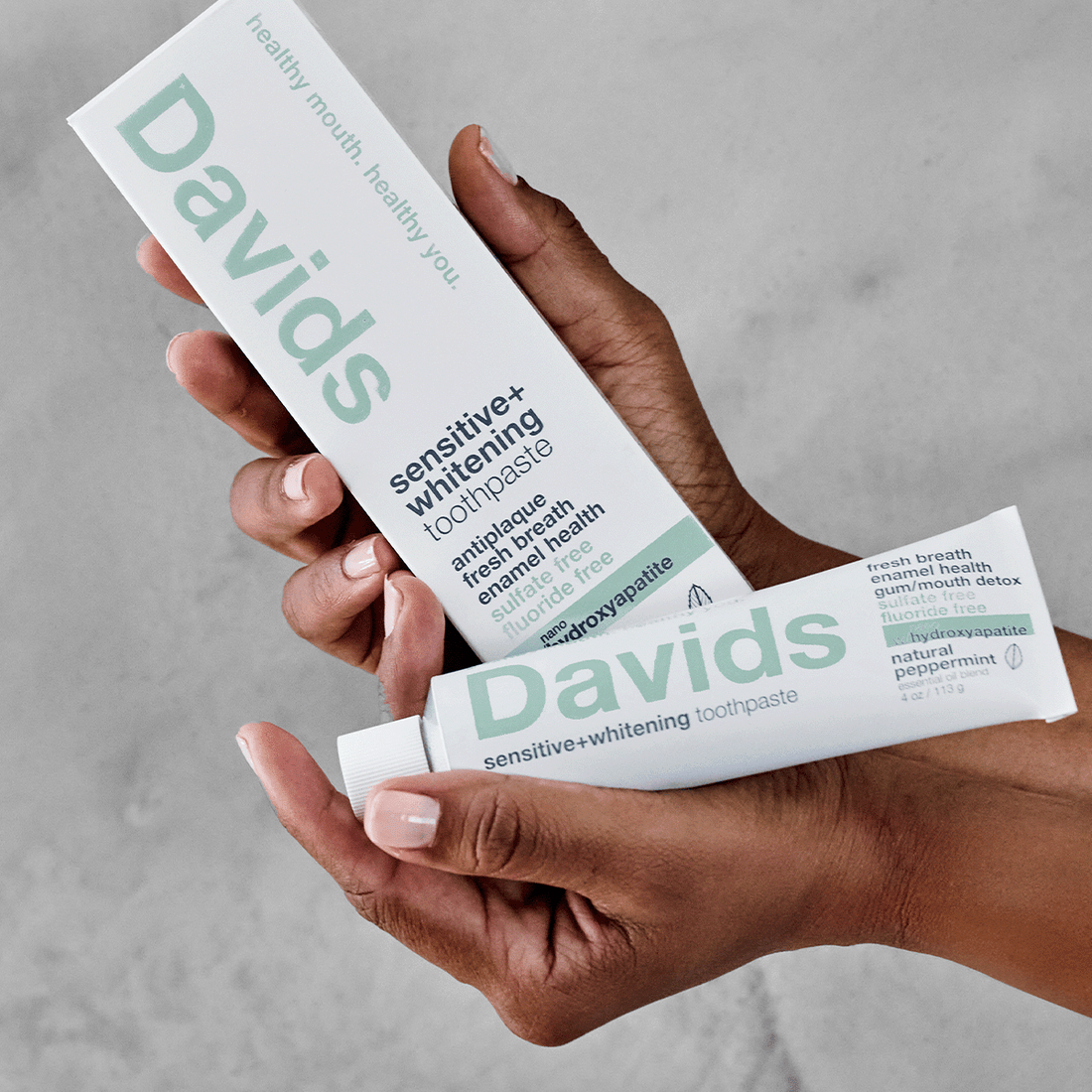 Hands holding Davids sensitive+whitening toothpaste and its box